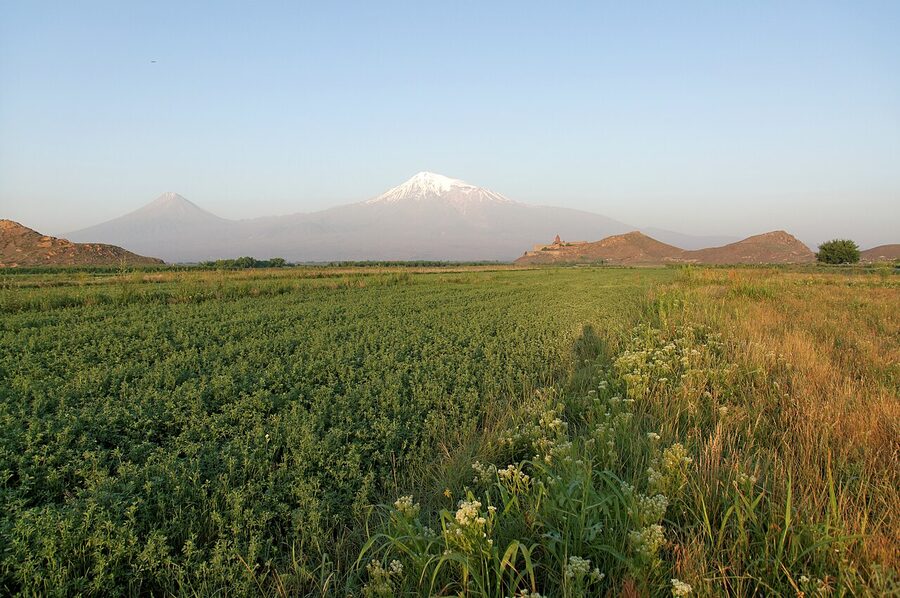 Mount Ararat above a field on the Ararat Plain with Khor Virap on its hill