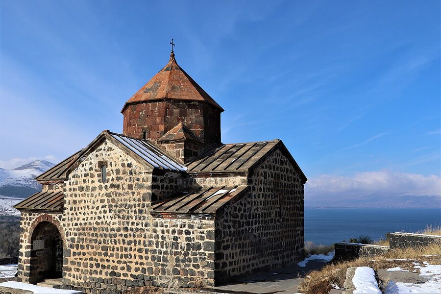 Carved stone interior detail at Sevanavank with a khachkar visible against the church wall