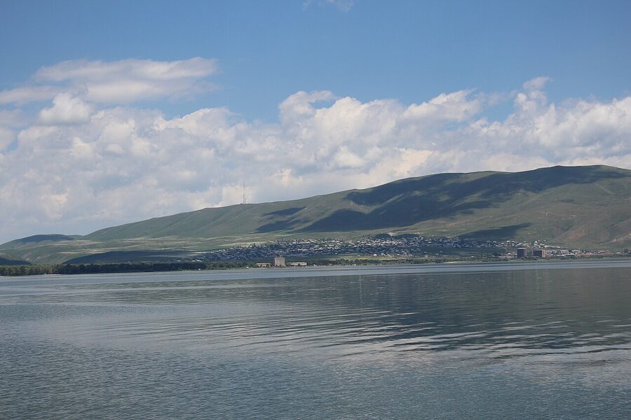 Lake Sevan shoreline in summer with green grass and clear water