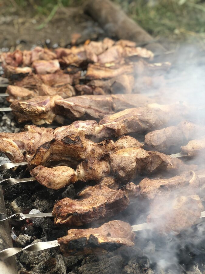Skewered Armenian khorovats grilling over a wood fire